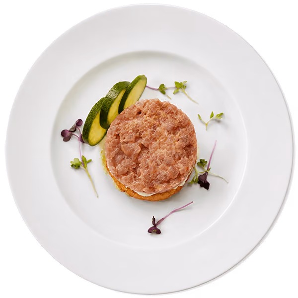 Fresh mixed green salad topped with crumbled feta cheese, mandarin orange slices, cucumber, olives, crispy wonton strips, and vinaigrette on a white plate.