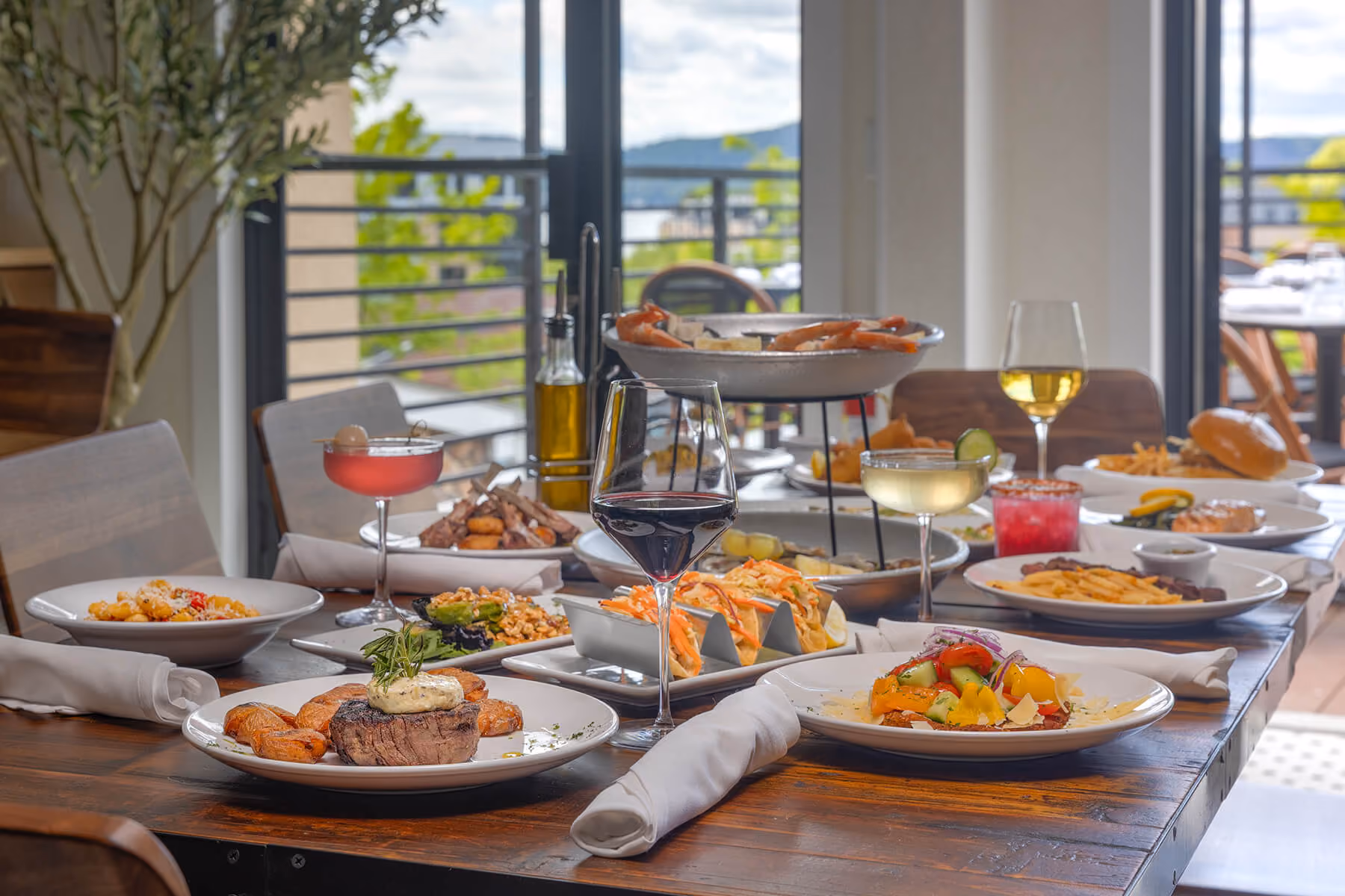 Beautiful table spread featuring fresh seafood, appetizers, entrées, and wine, perfect for sharing with family and friends.